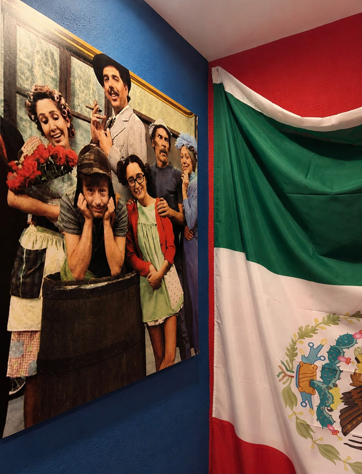 Mural de El Chavo del 8 junto a una bandera de México