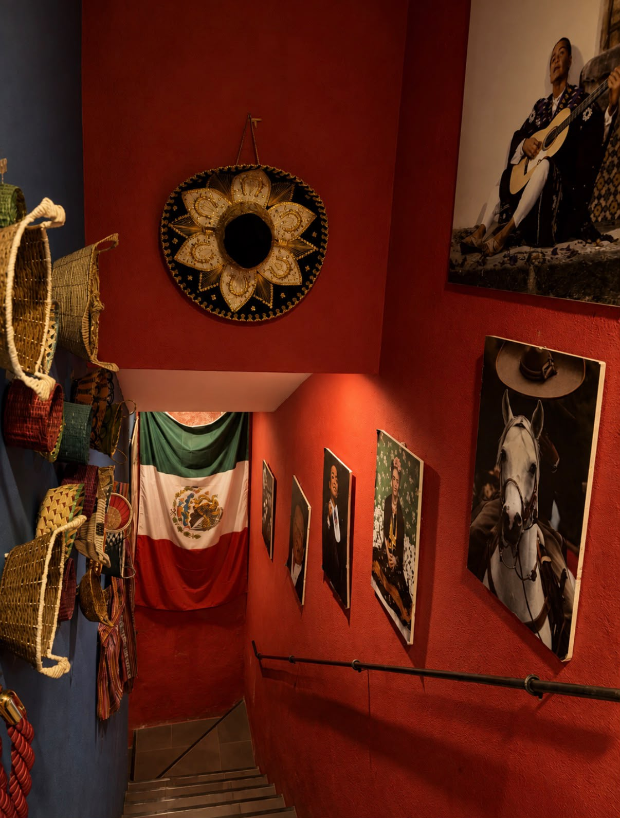 Escalera roja decorada con sombreros y retratos mexicanos