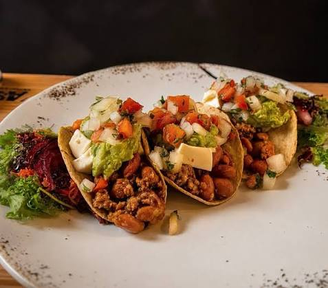 Tacos con carne picada, frijoles, guacamole y queso fresco