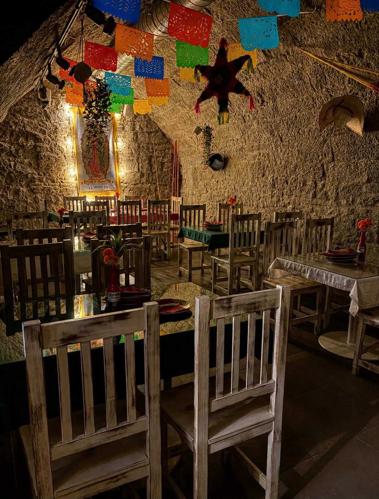 Salón del restaurante bajo bóveda de piedra, decorado con papel picado